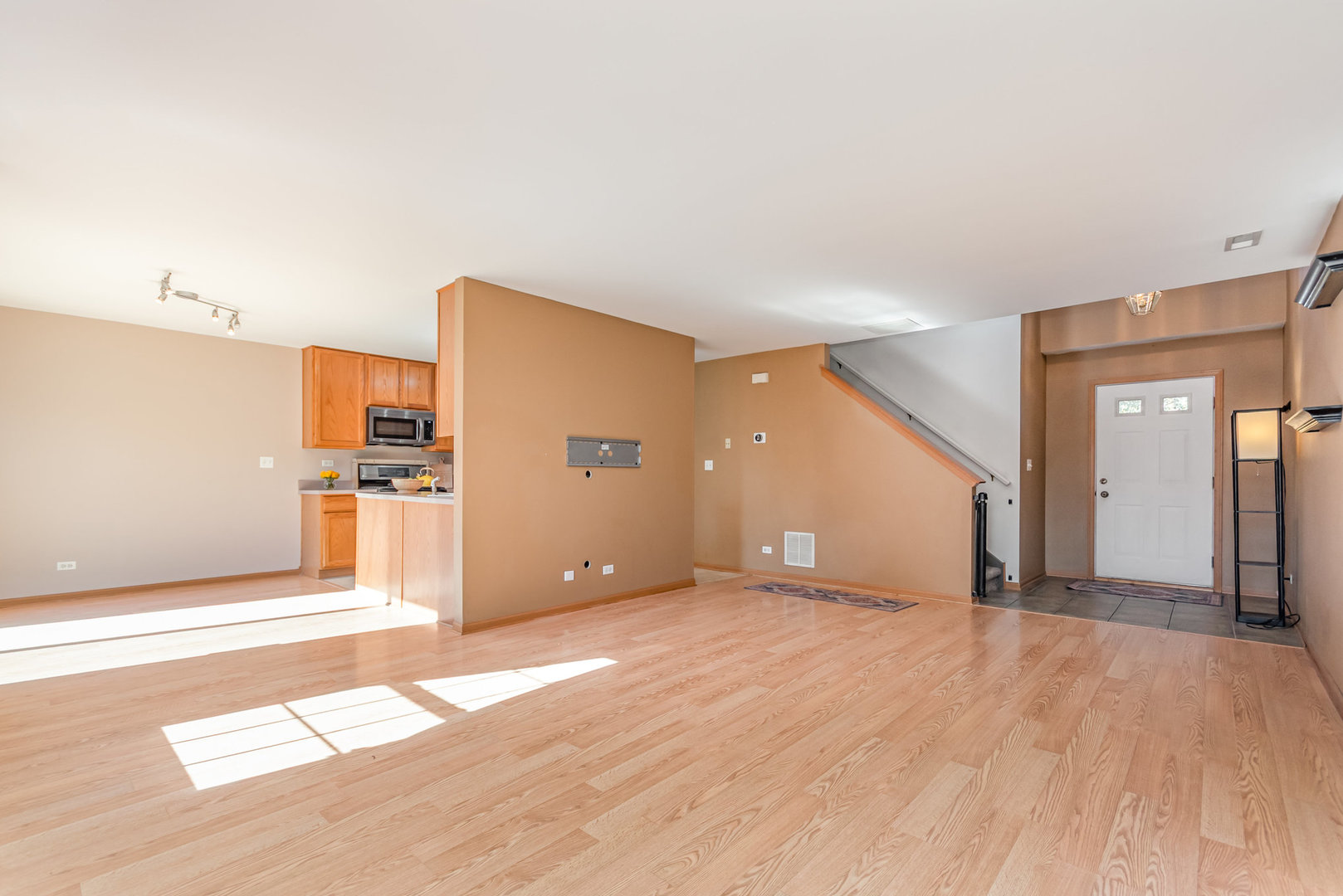 16043 Tiger Drive Lockport, IL 60441 - Photo 10 of 22 a view of a big room with wooden floor and kitchen view