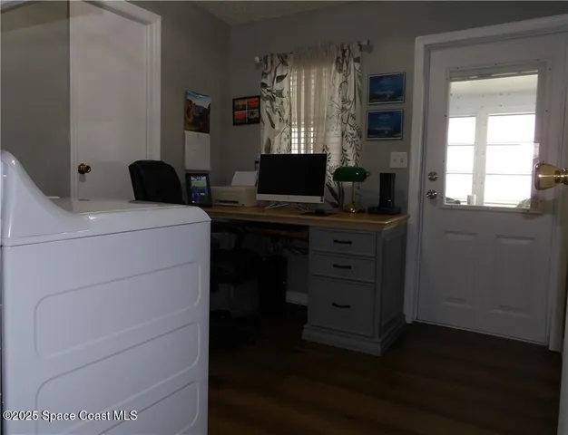 a view of a workspace with furniture and a window