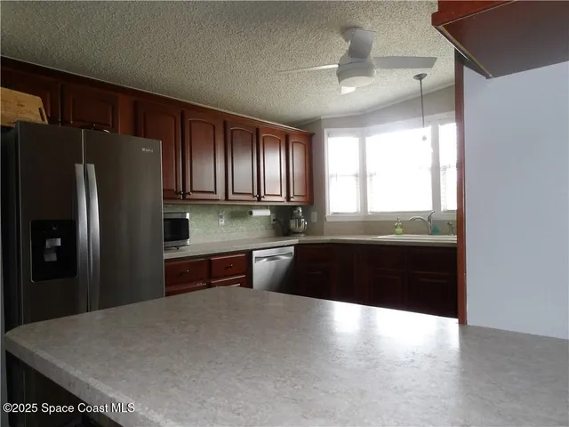 a kitchen with granite countertop a refrigerator and a sink