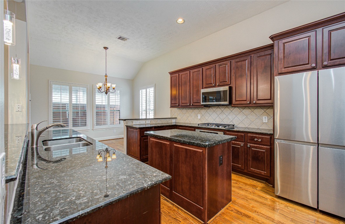 1463 Springrock Lane, Unit A Houston, TX 77055 - Photo 15 of 46 a kitchen with stainless steel appliances granite countertop a stove a sink dishwasher a refrigerator and wooden cabinets with wooden floor