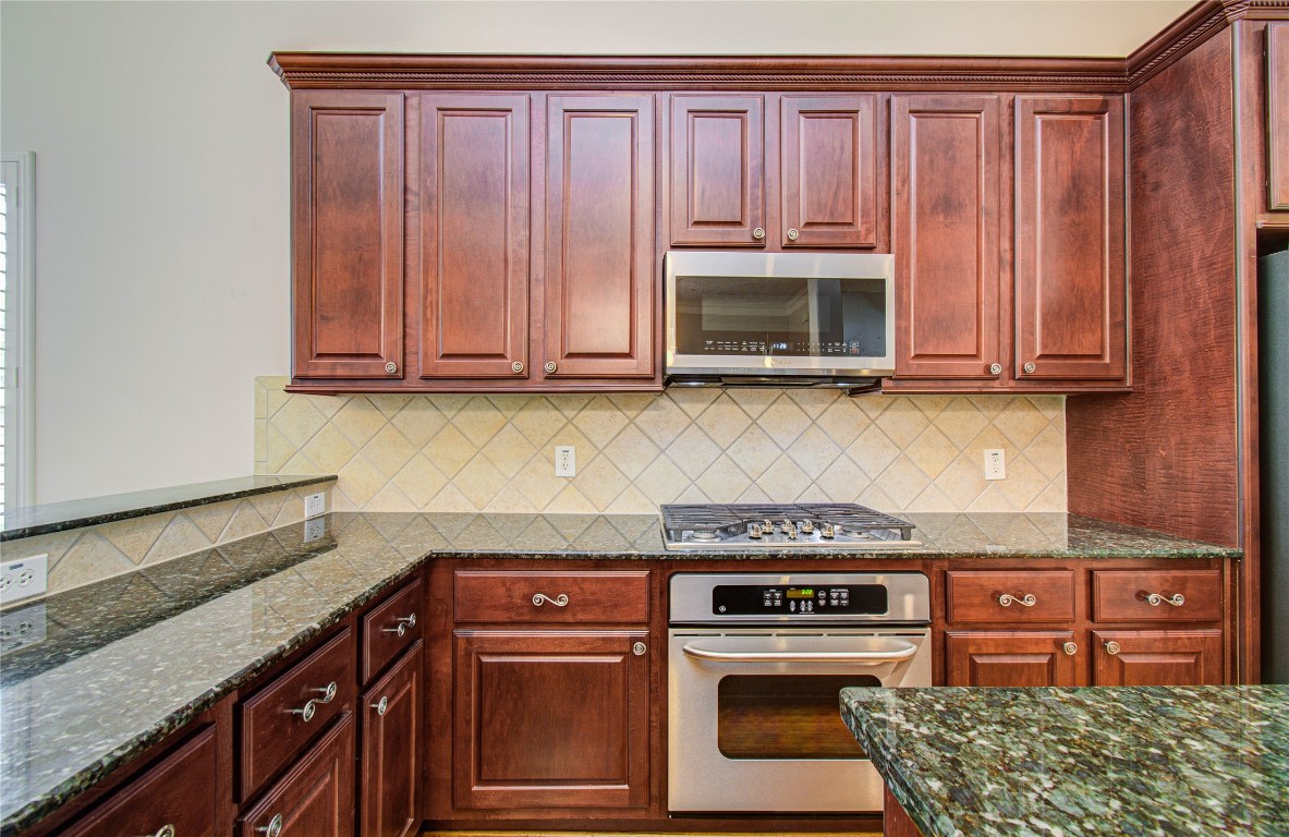 1463 Springrock Lane, Unit A Houston, TX 77055 - Photo 16 of 46 a kitchen with granite countertop wooden cabinets and a stove top oven