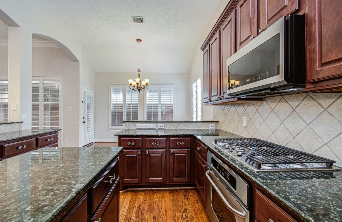 1463 Springrock Lane, Unit A Houston, TX 77055 - Photo 17 of 46 a kitchen with stainless steel appliances granite countertop a stove and a microwave