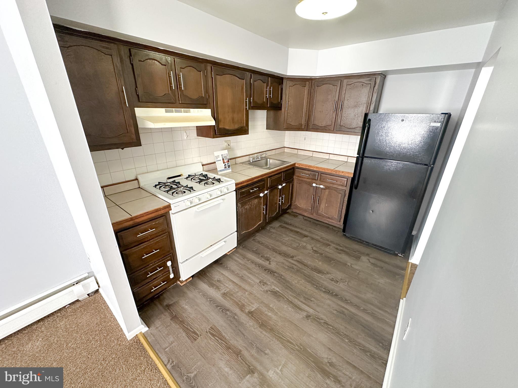 a kitchen with a stove a refrigerator and a sink