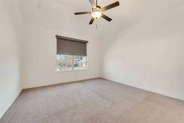 an empty room with a window and a fan
