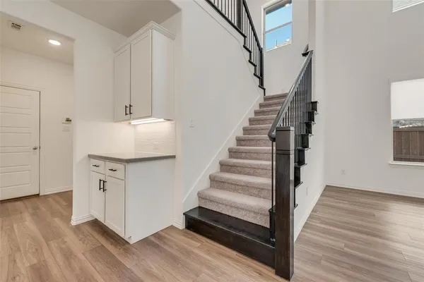 a view of a hallway with wooden floor and staircase