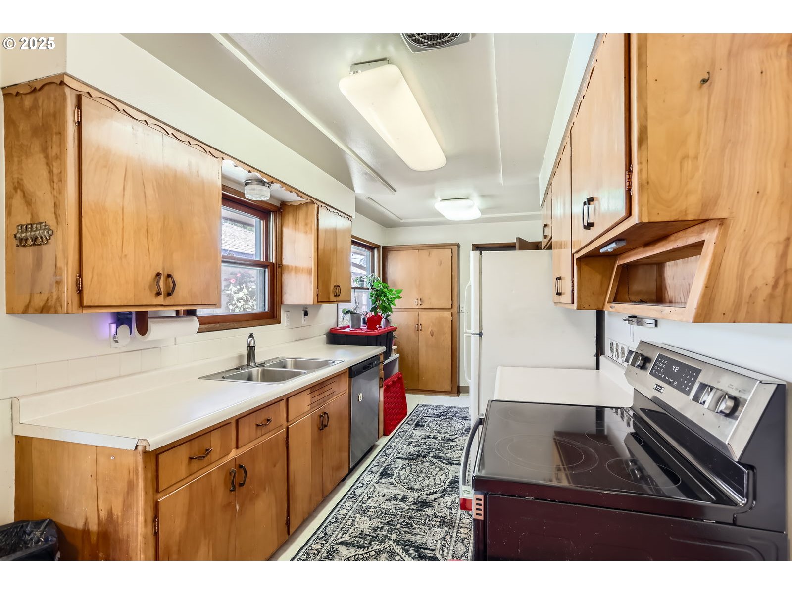 14031 Southeast Rhone Street Portland, OR 97236 - Photo 12 of 29 a kitchen with a sink stove and cabinets