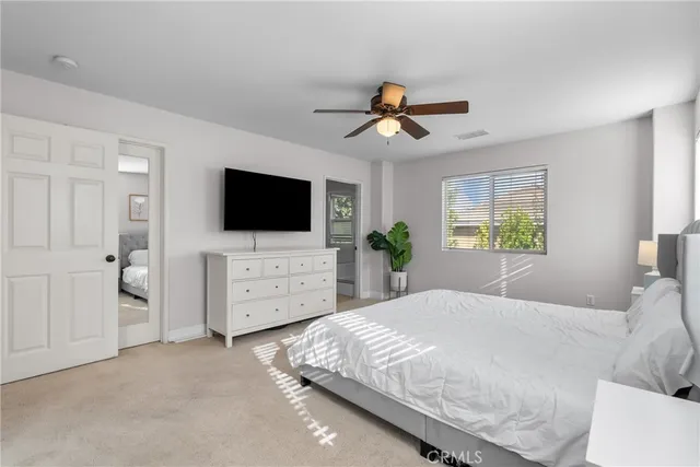 a bedroom with a bed a tv on dresser and a window