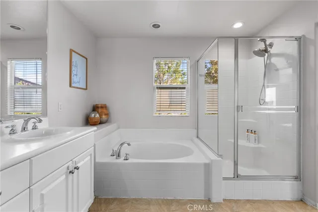 a bathroom with a bathtub a shower a sink and a window
