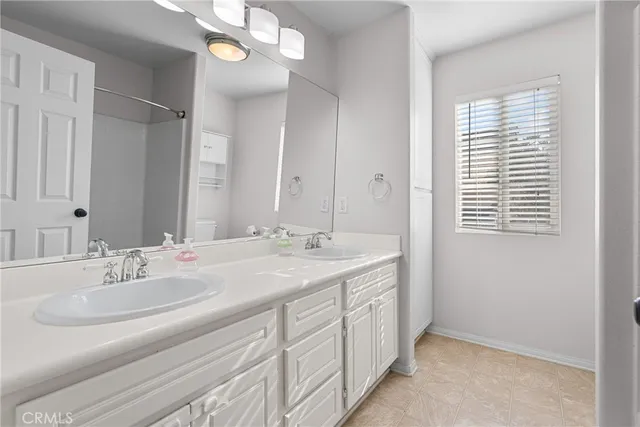 a bathroom with a double vanity sink and a mirror