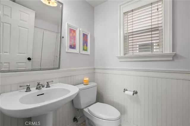 a bathroom with a sink a toilet and mirror