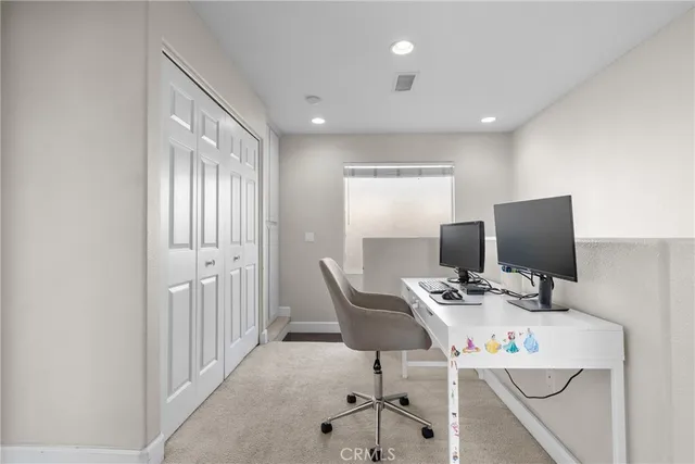 a view of a workspace with furniture and a window