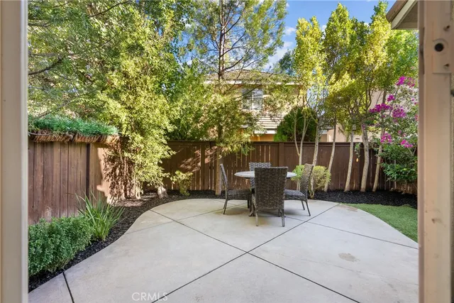 a view of a patio with a table and chairs and potted plants