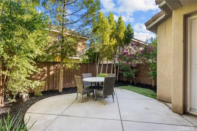 a view of a chairs and table in the back yard of the house