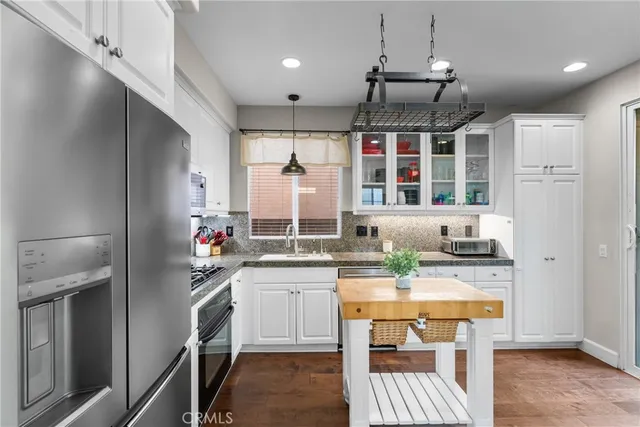 a kitchen with kitchen island a large counter top space appliances and cabinets