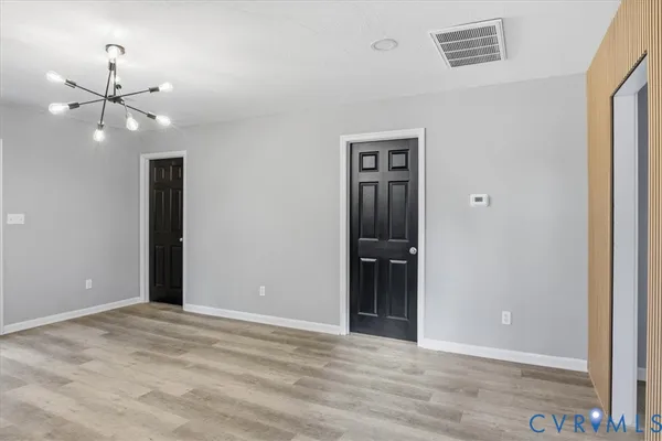an empty room with closet and a chandelier fan