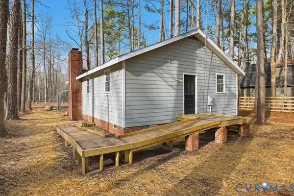 a view of a house with wooden deck and furniture
