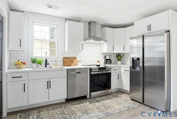 a kitchen with stainless steel appliances granite countertop a refrigerator sink and cabinets