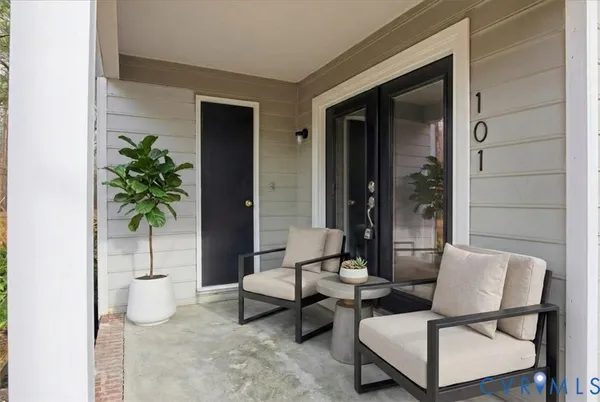 a living room with patio furniture and a potted plant