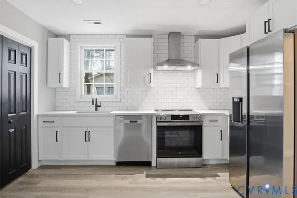 a kitchen with stainless steel appliances granite countertop a stove a refrigerator and a sink