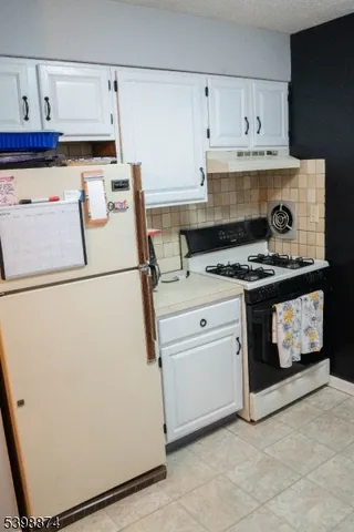 a kitchen with a stove and white cabinets