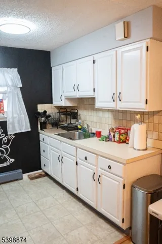 a kitchen with granite countertop white cabinets and sink