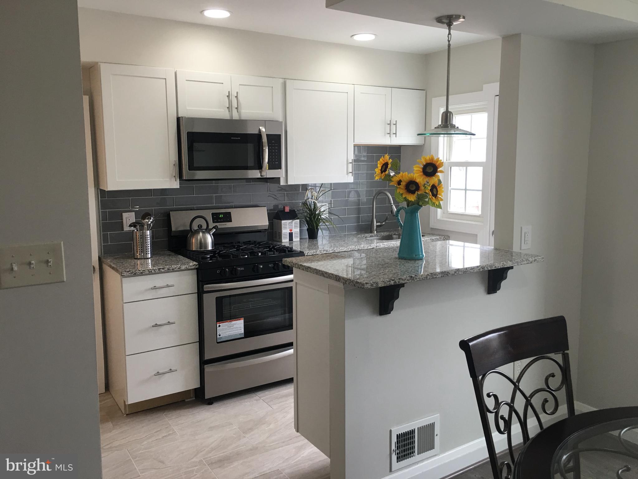 7968 Kavanagh Road Baltimore, MD 21222 - Photo 9 of 30 a kitchen with stainless steel appliances granite countertop a stove a sink and a microwave
