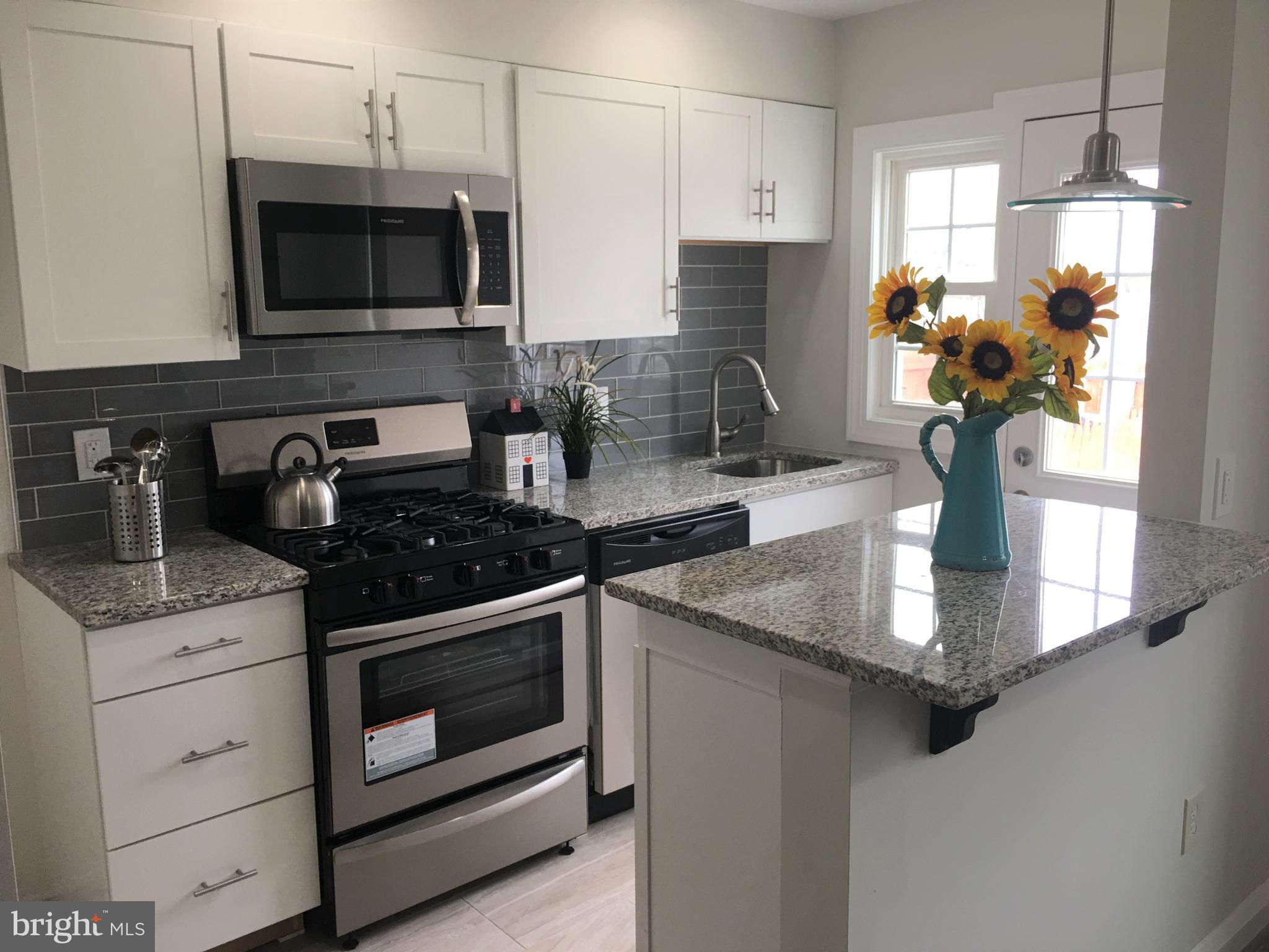7968 Kavanagh Road Baltimore, MD 21222 - Photo 10 of 30 a kitchen with a stove and a white cabinet