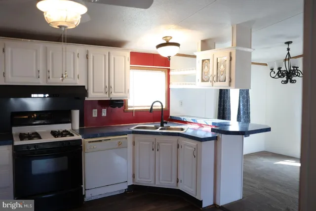 a kitchen with cabinets and chandelier