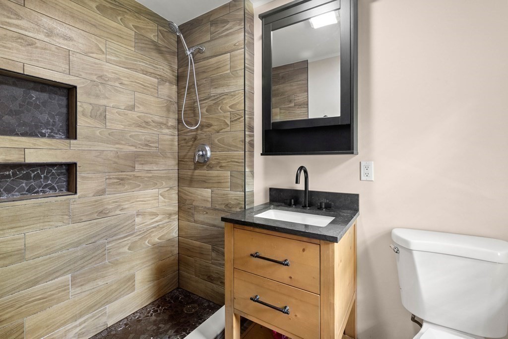 73 Baldwin Road Billerica, MA 01821 - Photo 26 of 40 a bathroom with a granite countertop sink toilet and mirror