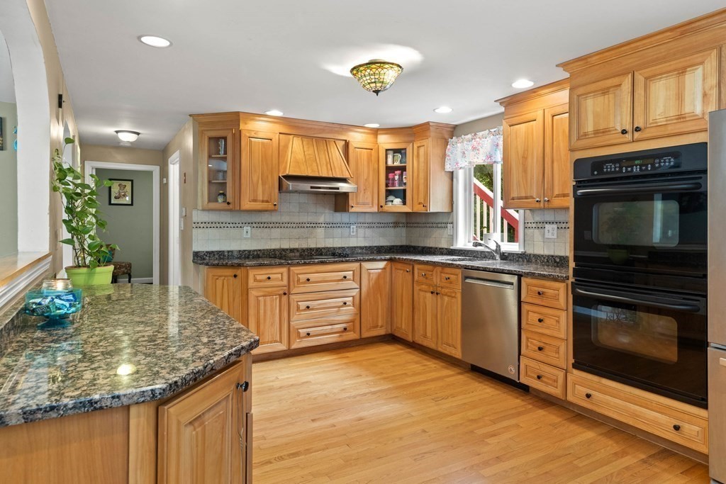 73 Baldwin Road Billerica, MA 01821 - Photo 9 of 40 a kitchen with stainless steel appliances granite countertop a stove a sink and a microwave