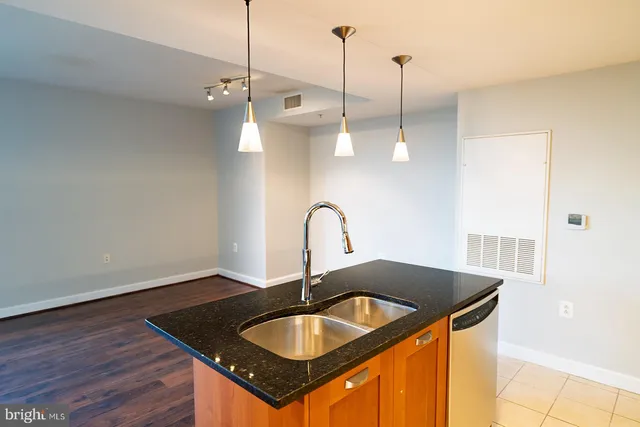 a kitchen with kitchen island a sink and wooden floor