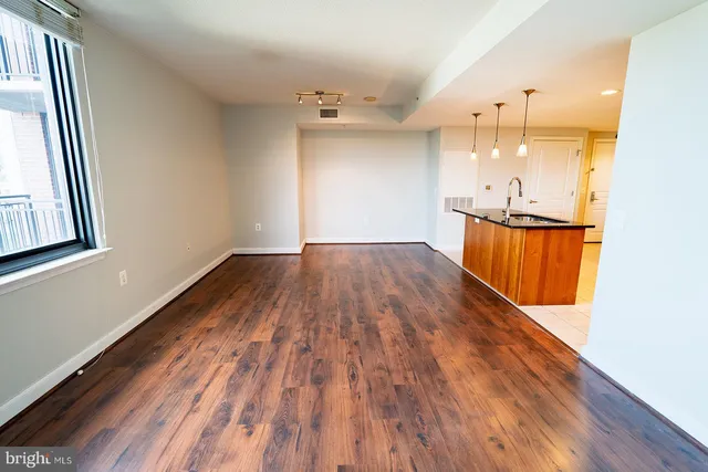 a view of a kitchen with wooden floor and a sink