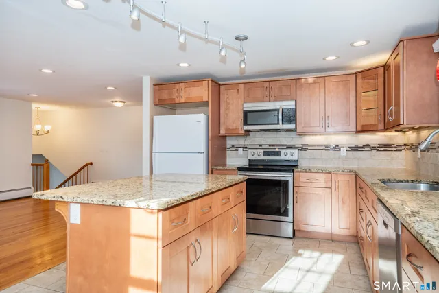a kitchen with stainless steel appliances granite countertop a stove top oven a sink and a granite counter tops