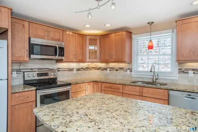 a kitchen with stainless steel appliances granite countertop a stove microwave and sink