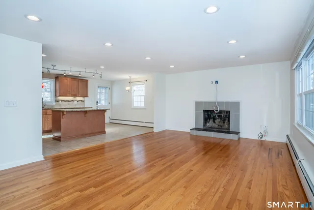 an empty room with wooden floor and fireplace