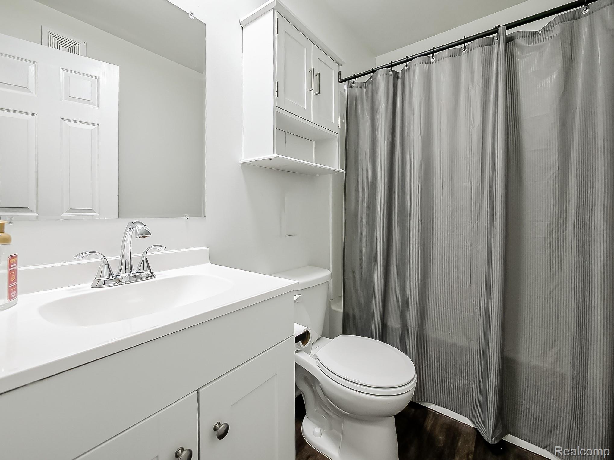 4905 South Crooks Road Royal Oak, MI 48073 - Photo 13 of 28 Full bathroom with vanity, shower / bath combination with curtain, and dark wood-type flooring
