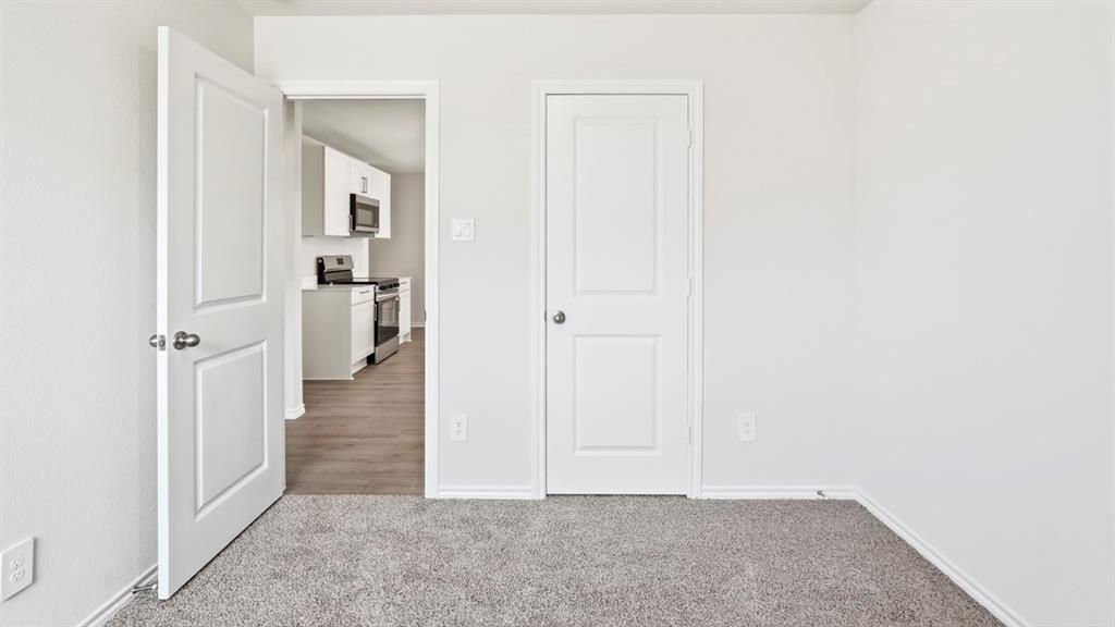 3319 Twilight Trail Forney, TX 75126 - Photo 31 of 33 Interior space featuring light gray textured carpeting and white painted walls