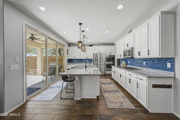 a large kitchen with kitchen island a large counter space a sink appliances and cabinets