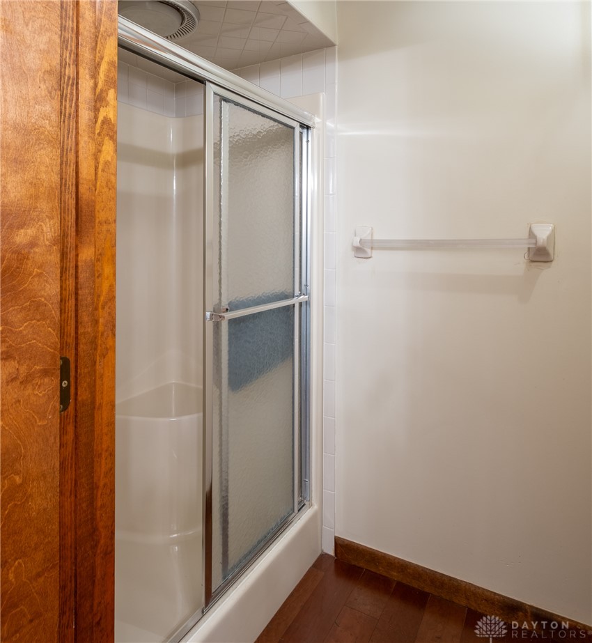 273 North Alpha Bellbrook Road Dayton, OH 45434 - Photo 26 of 43 This bathroom features a shower with sliding doors and rich wood flooring.