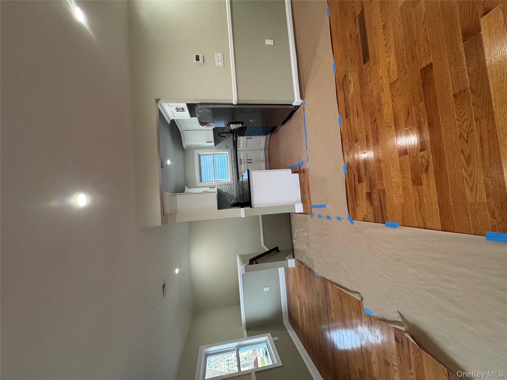 118-32 200th Street, Unit 2 Queens, NY 11412 - Photo 5 of 5 Kitchen with open floor plan, white cabinetry, recessed lighting, light wood-style floors, and refrigerator