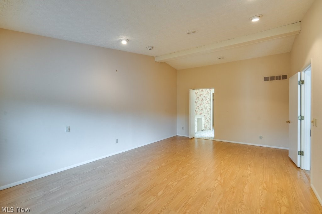 3388 South Smith Road Fairlawn, OH 44333 - Photo 14 of 31 Primary Bedroom with laminant floors, vaulted Ceiling with entrance to large Master Bath with Walk in Closet, Soaking tub and separate shower.