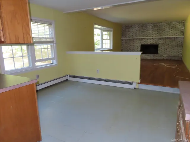 an empty room with a fireplace and windows