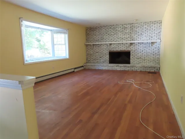 a view of empty room with fireplace and window