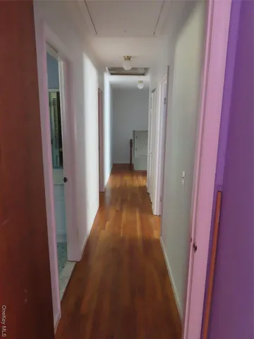 a view of a hallway with wooden floor