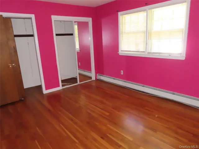 a view of empty room with wooden floor and windows