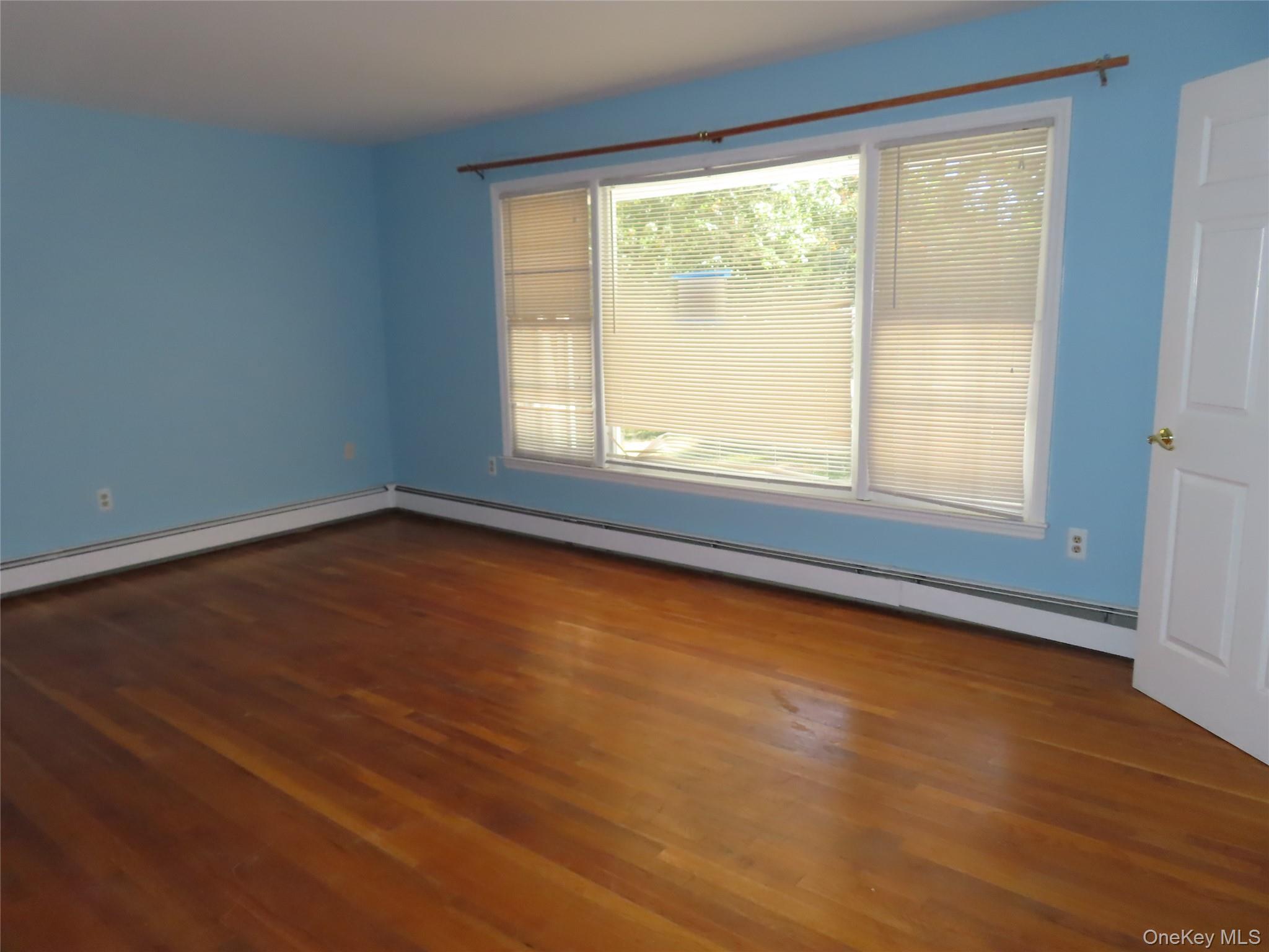 26 Darren Road LaGrangeville, NY 12540 - Photo 6 of 28 Spare room featuring a baseboard radiator and dark wood finished floors