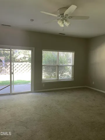 an empty room with windows ceiling fan and windows