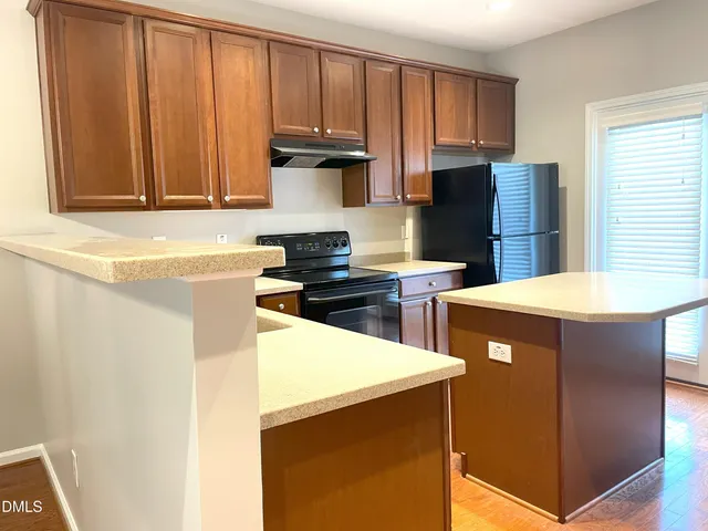 a kitchen with stainless steel appliances wooden cabinets a refrigerator and a sink