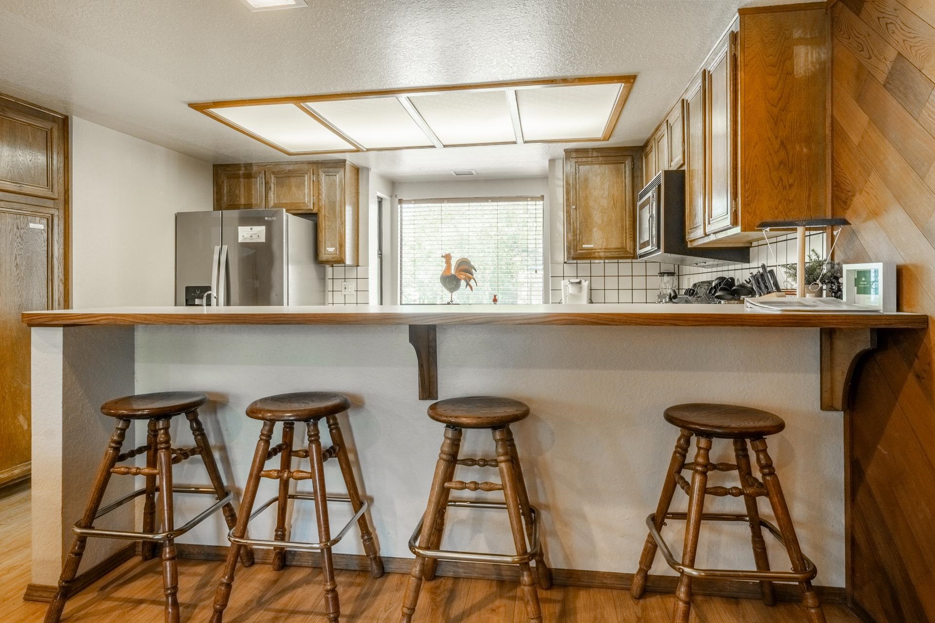 384 Joaquin Road, Unit 36 Mammoth Lakes, CA 93546 - Photo 13 of 36 Kitchen featuring wood-finish cabinetry, white tile backsplash, stainless steel refrigerator, and recessed lighting