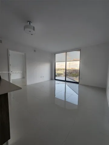 an empty room with windows and ceiling fan